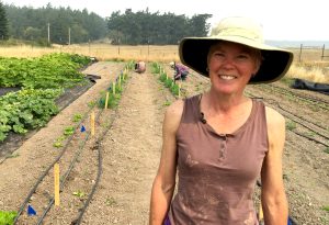 Christine Langley in front of a vegetable field.